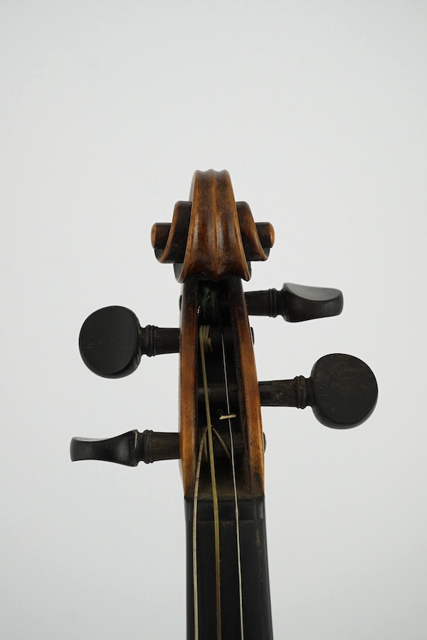 A late 19th century German Nuremberg school violin c.1880, Stradivarius pattern with a finely carved scroll and a large 14.25 inch body, together with a fully mounted German octagonal bow, contained within a contemporary